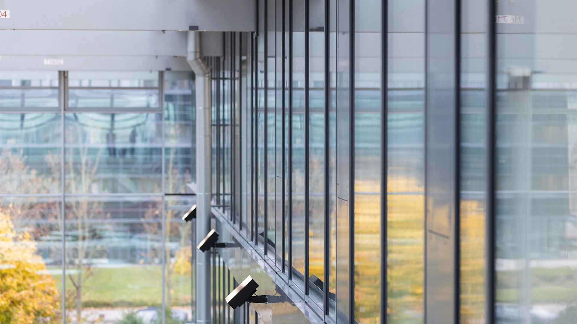 Exterior view of a modern office building with a glass facade and wall spotlights. (photo)